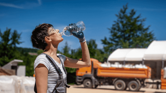 Female laborer drinking water in extreme heat
