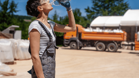 Female laborer drinking water in extreme heat