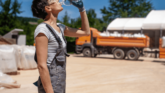 Female laborer drinking water in extreme heat