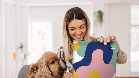 Woman with dog opening Branded Merchandise Kit from HALO