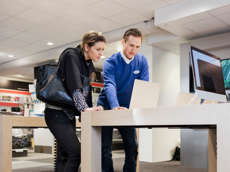 employee in retail uniform helping shopper